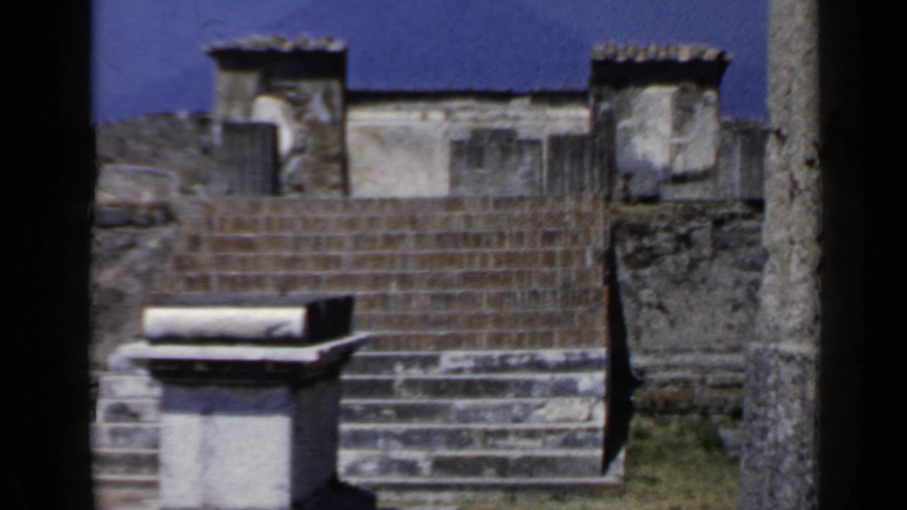 Stone steps and weathered walls under a bright blue sky.
