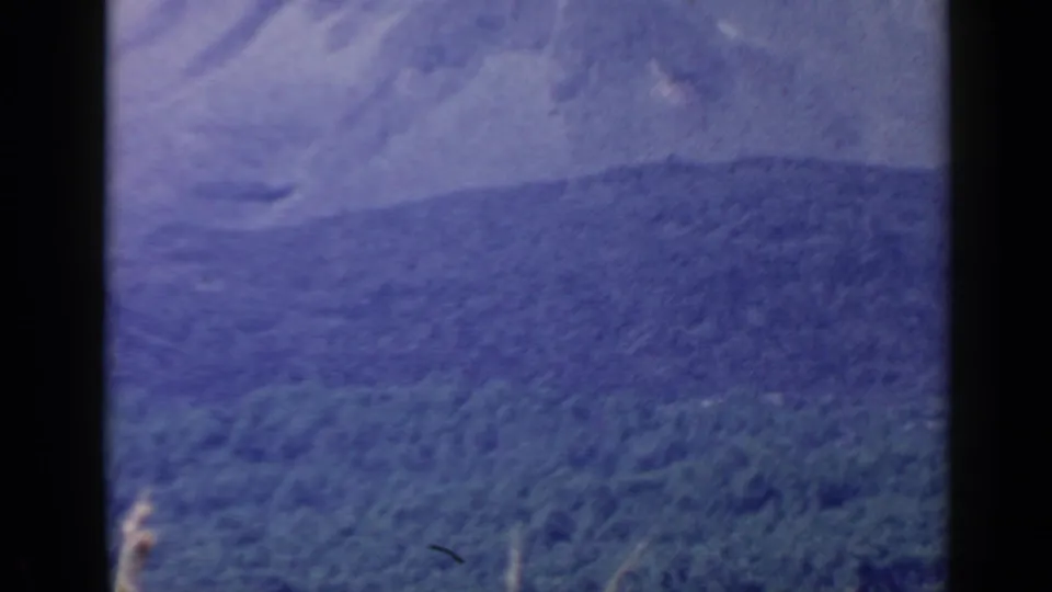 Soft 8mm frame showing a distant wooded ridge and hazy mountain form in the Rome, Italy travel sequence.