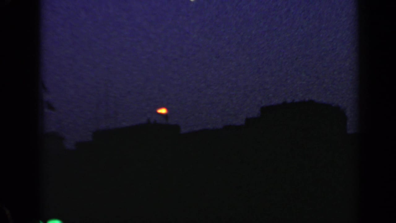 1960 Rome 8mm frame with dark roof silhouettes and a bright orange point in the low evening sky.