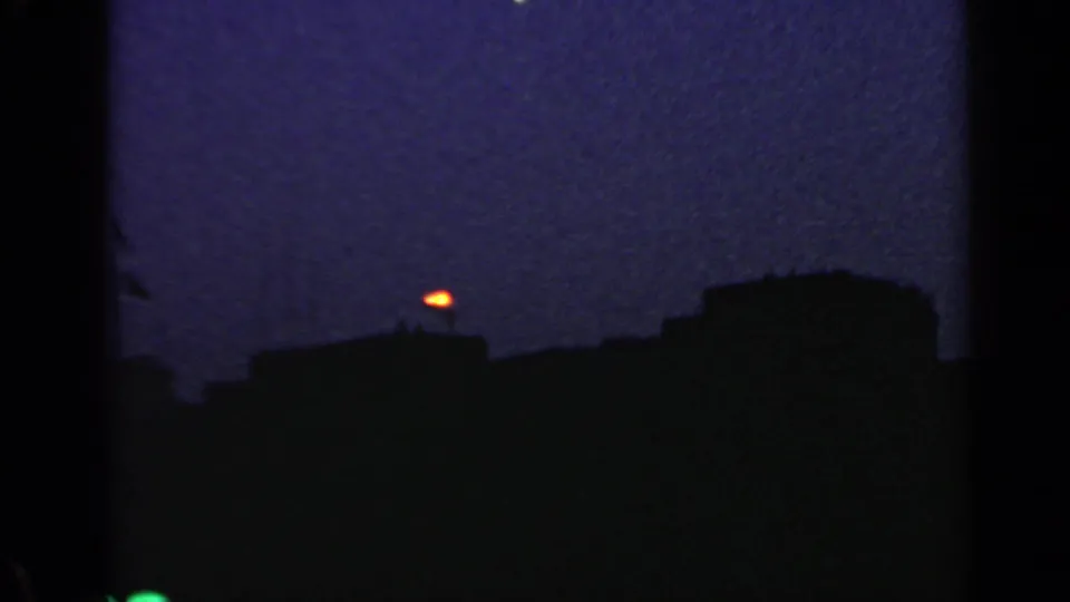 1960 Rome 8mm frame with dark roof silhouettes and a bright orange point in the low evening sky.