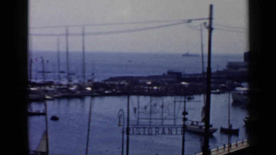 1960 Rome waterfront view with marina masts, open blue water, dock railings, lamps, and a readable RISTORANTE sign.