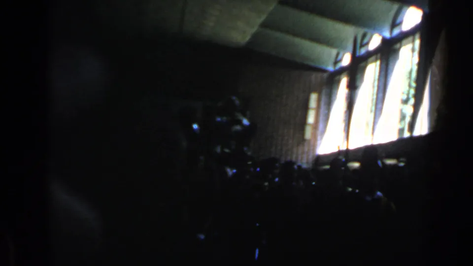 Final frame of the 1960 Rome clip showing a dim interior, bright window openings, and indistinct gathered forms.