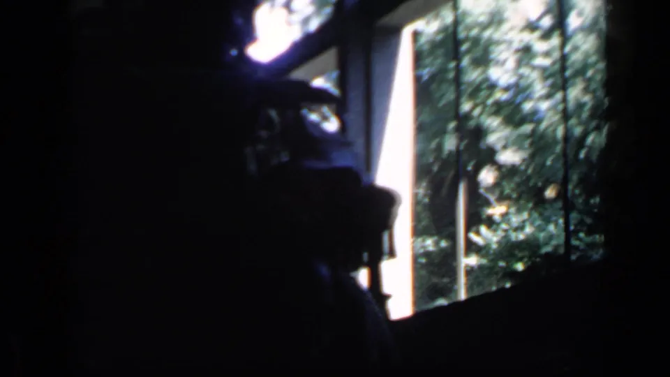 A dark 1960 Rome frame shows a likely ceremonial chair and surrounding figures silhouetted against bright windows and outdoor foliage.