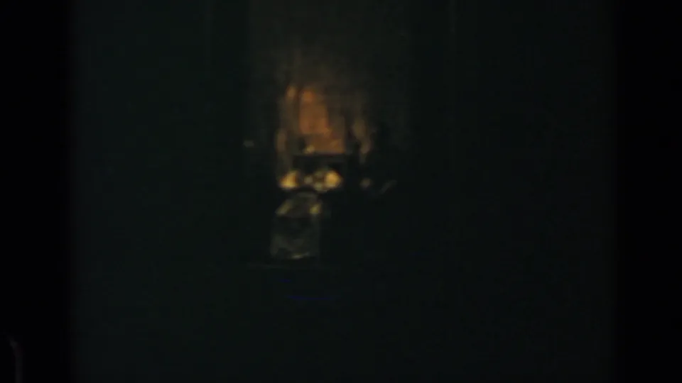 1960 Rome 8mm frame with a small warm flash-lit area emerging from a nearly black interior.