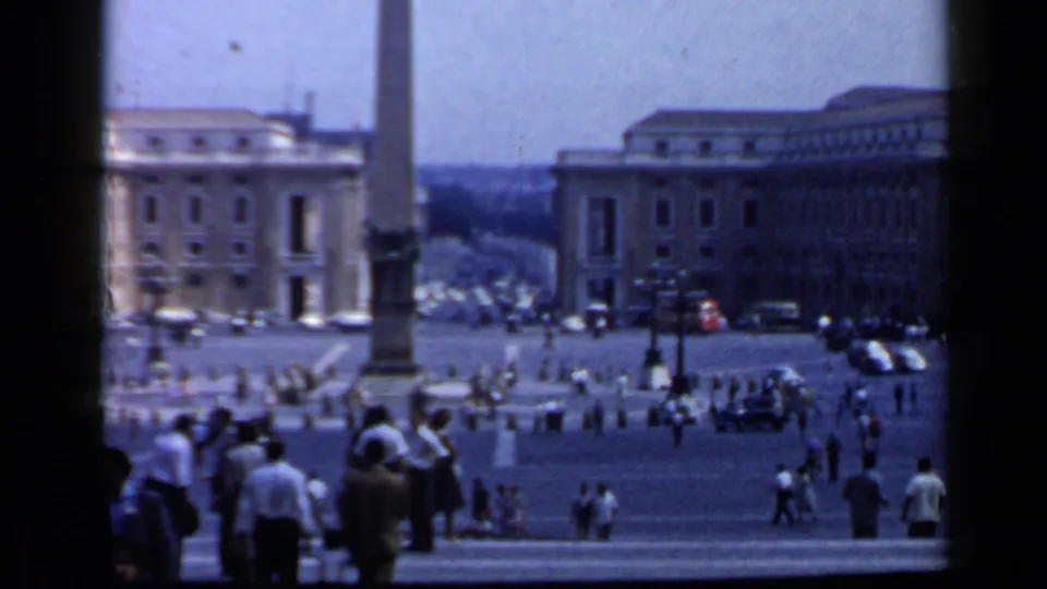 1960 Vatican frame looking across St. Peter's Square from the colonnade, with visitors, buildings, and the obelisk base visible.
