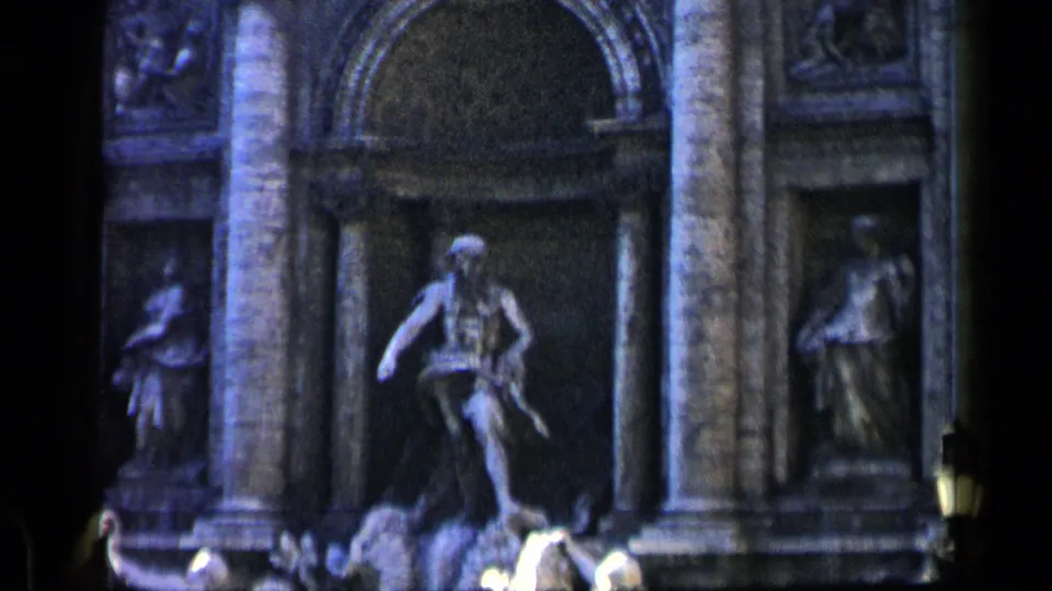 1960 8mm close view of a Rome landmark fountain area, showing carved figures, stone columns, niches, and a bright water basin.