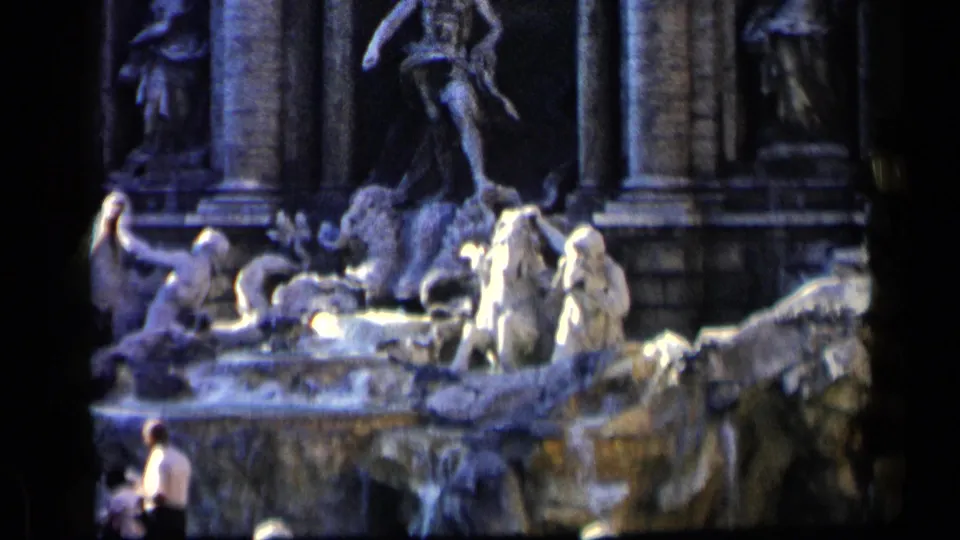 1960 8mm view of Rome's Trevi Fountain, with the sculptural group filling the frame and a small visitor partly visible at lower left.