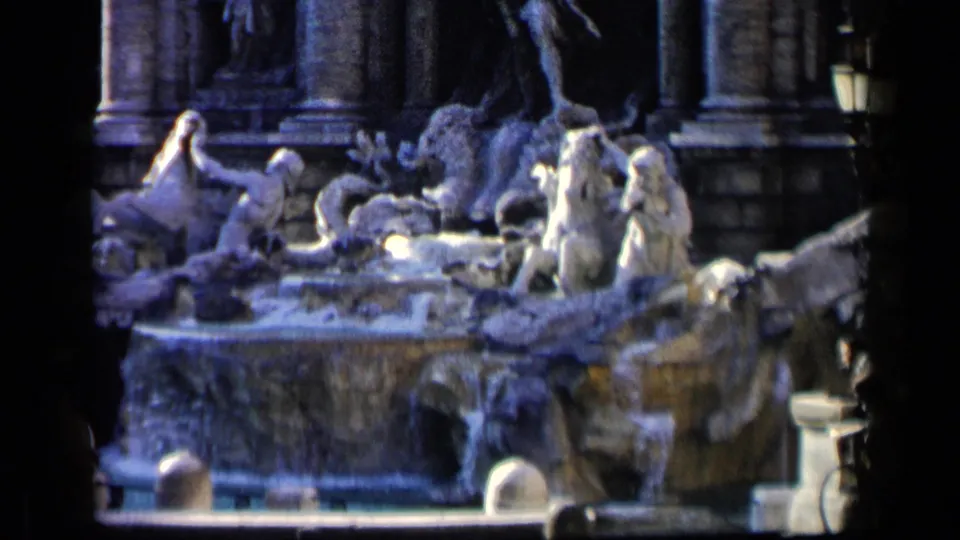Visitor-shot 1960 Italian fountain scene with Baroque-style sculpture, water, and partial pedestrians.