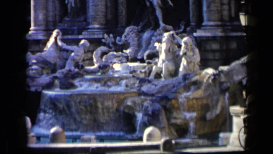 A soft 8mm frame centers on the Trevi Fountain's sculpted figures and water, with a few tourists partly visible around the public viewing area.