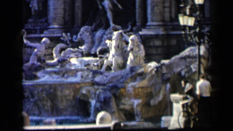 Rome travel footage shows the Trevi Fountain with tourists nearby and a man beside a bicycle at the edge of the frame.