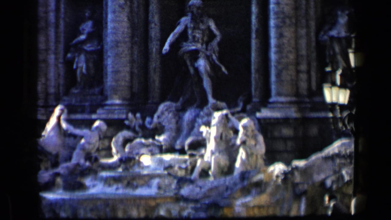 Trevi Fountain statuary with stone figures, columns, water, and a lamp at the right edge.