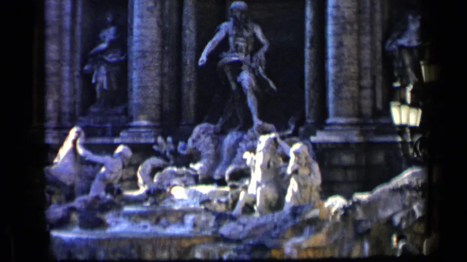 Circa-1960 8mm travel footage frames the Trevi Fountain's sculptural group, water, columns, and right-side lamp in Rome.