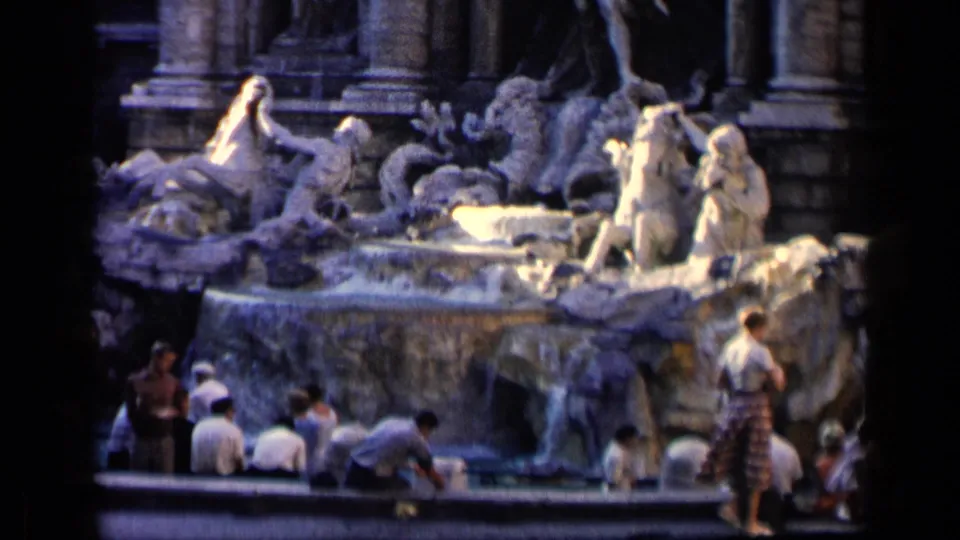1960 Rome travel footage showing visitors near the Trevi Fountain's sculpted figures and flowing water.