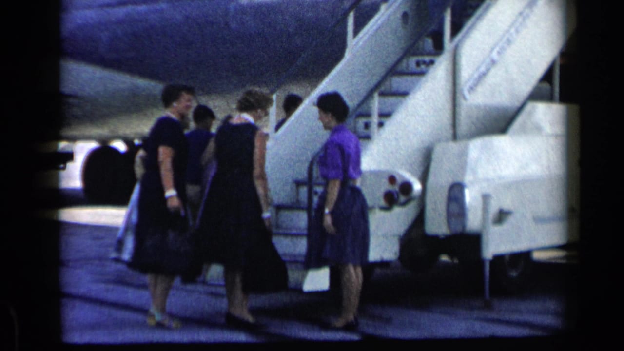 Women and other passengers approach a mobile airplane stairway with bags in 1960 Vatican, Italy metadata context.