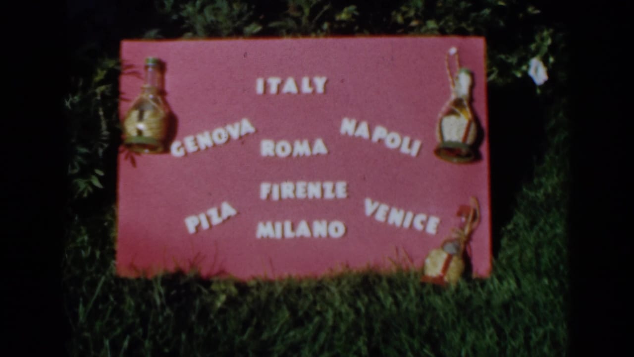 Pink Italy travel display board with city names and small decorative bottles.