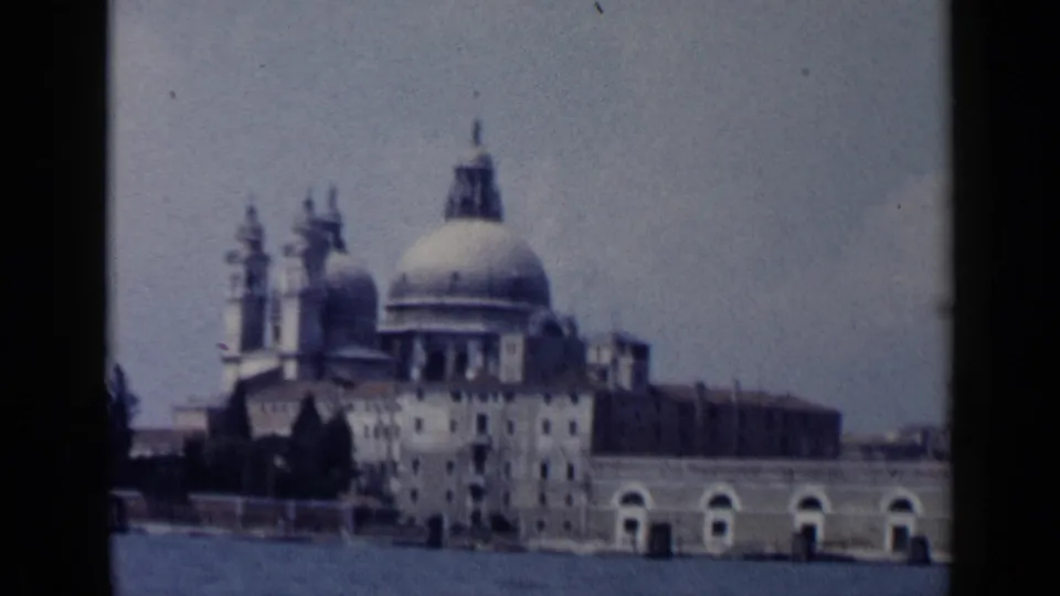 The final frame holds on a Venice waterfront landmark with a large dome, towers, arches, and water in the foreground.