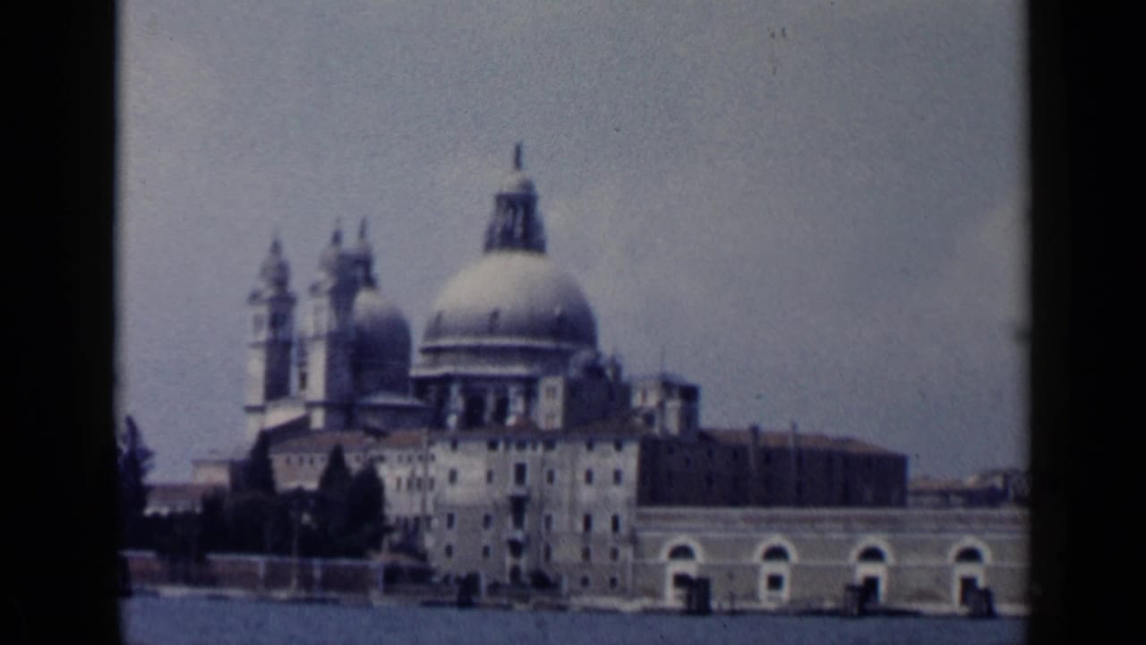 Santa Maria della Salute seen across the water with domes and towers under a hazy sky.