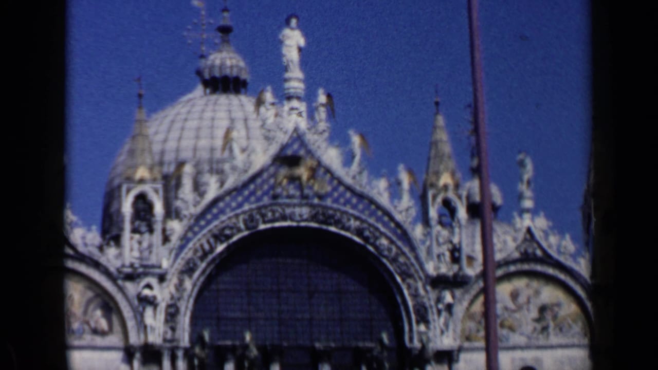 1960 Venice view of St. Mark's Basilica centered on the large dome, upper arch, spires, statues, and patterned exterior detail.
