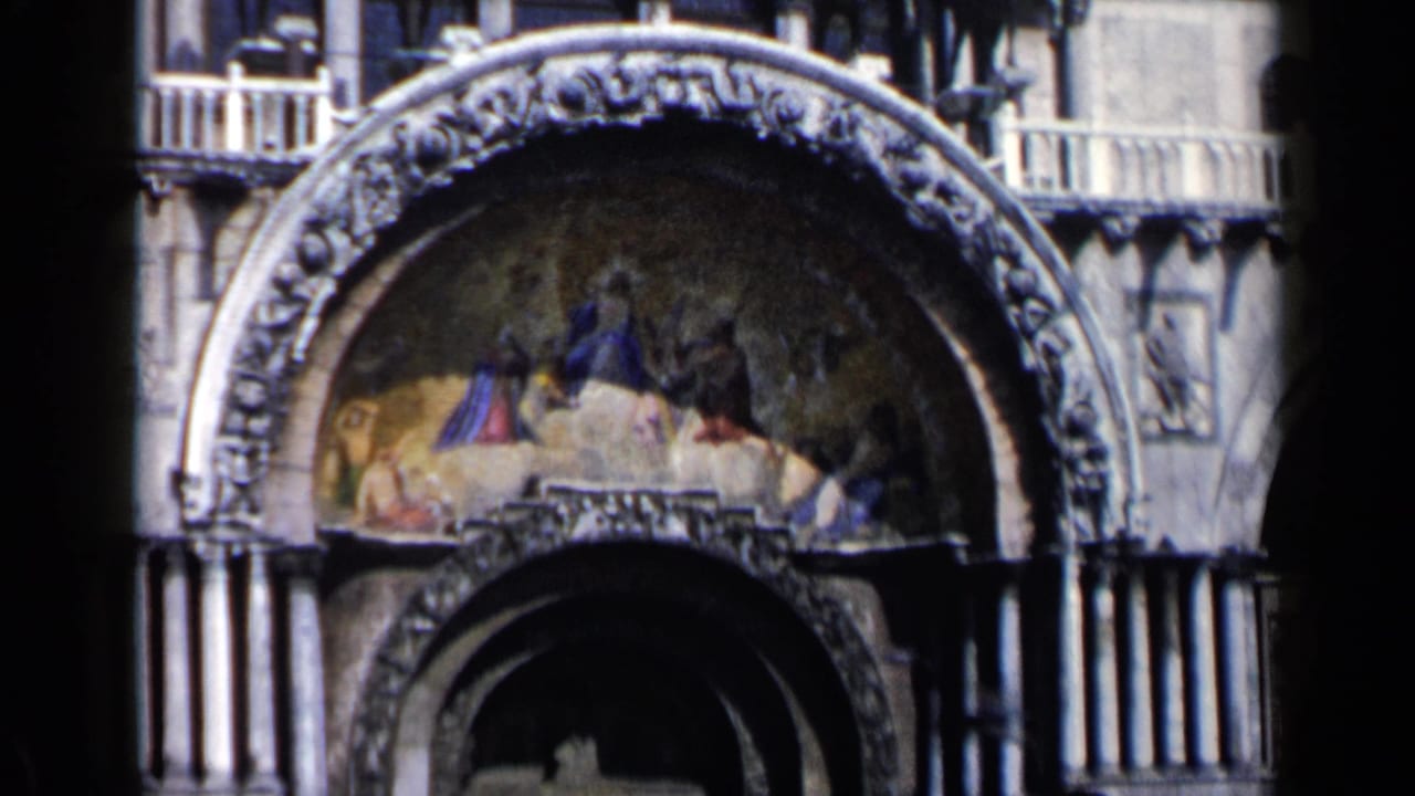 Close 1960 Venice view of a decorated arch, mosaic lunette, columns, and upper balcony detail on St. Mark's Basilica.