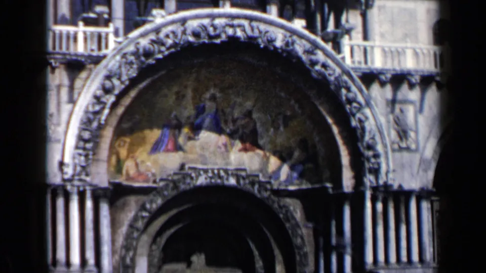 Close 1960 Venice view of a decorated arch, mosaic lunette, columns, and upper balcony detail on St. Mark's Basilica.