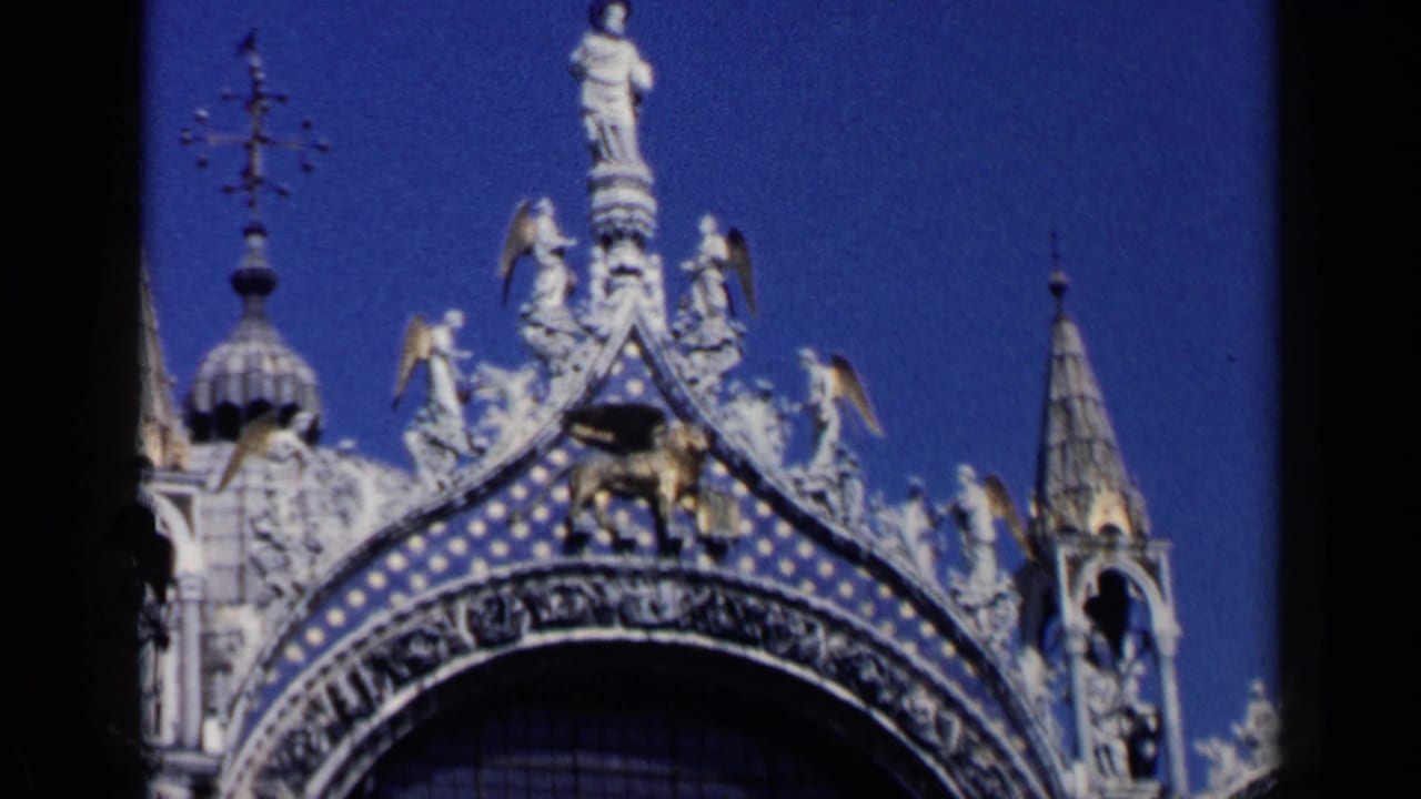 Close view of ornate St Mark's Basilica facade with sculptures and blue sky.