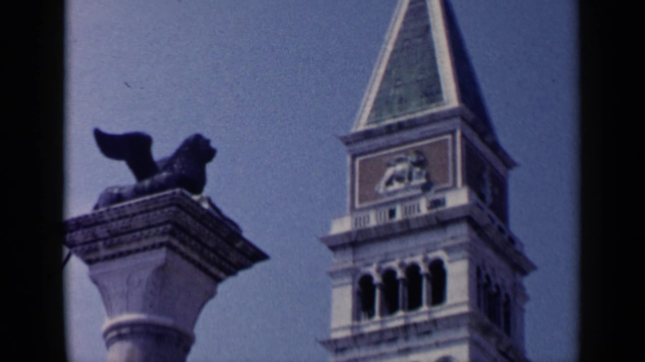 1960 Venice 8mm frame showing the Campanile di San Marco beside the winged lion column in Piazza San Marco.
