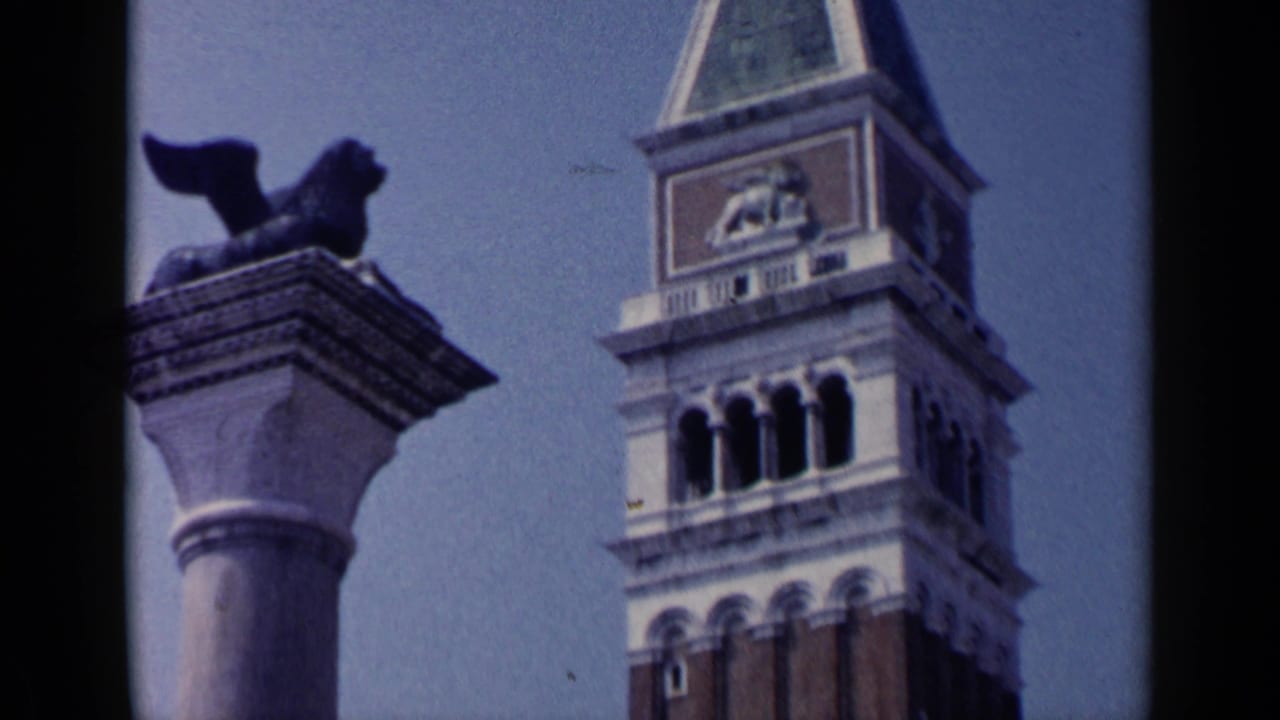 Visitor-shot 1960 Venice view of the winged lion statue and upper Campanile di San Marco, with film-edge framing.