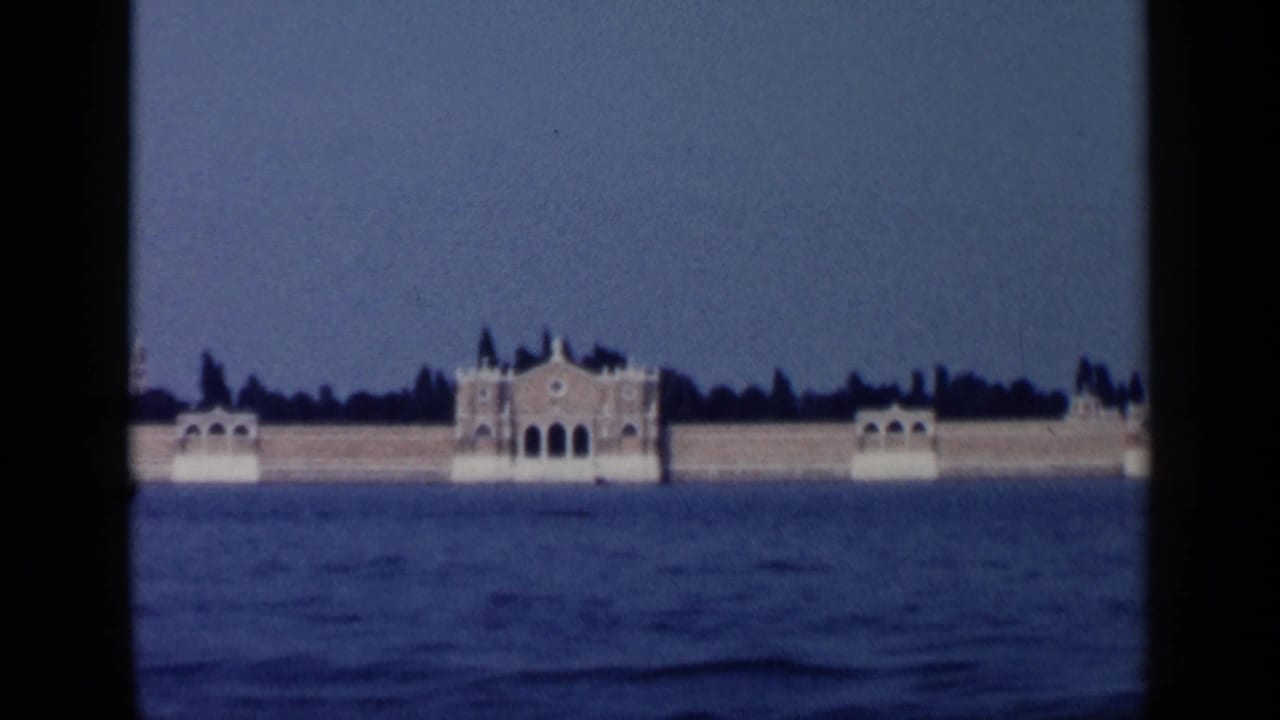 Distant ornate building across open water under a blue sky.
