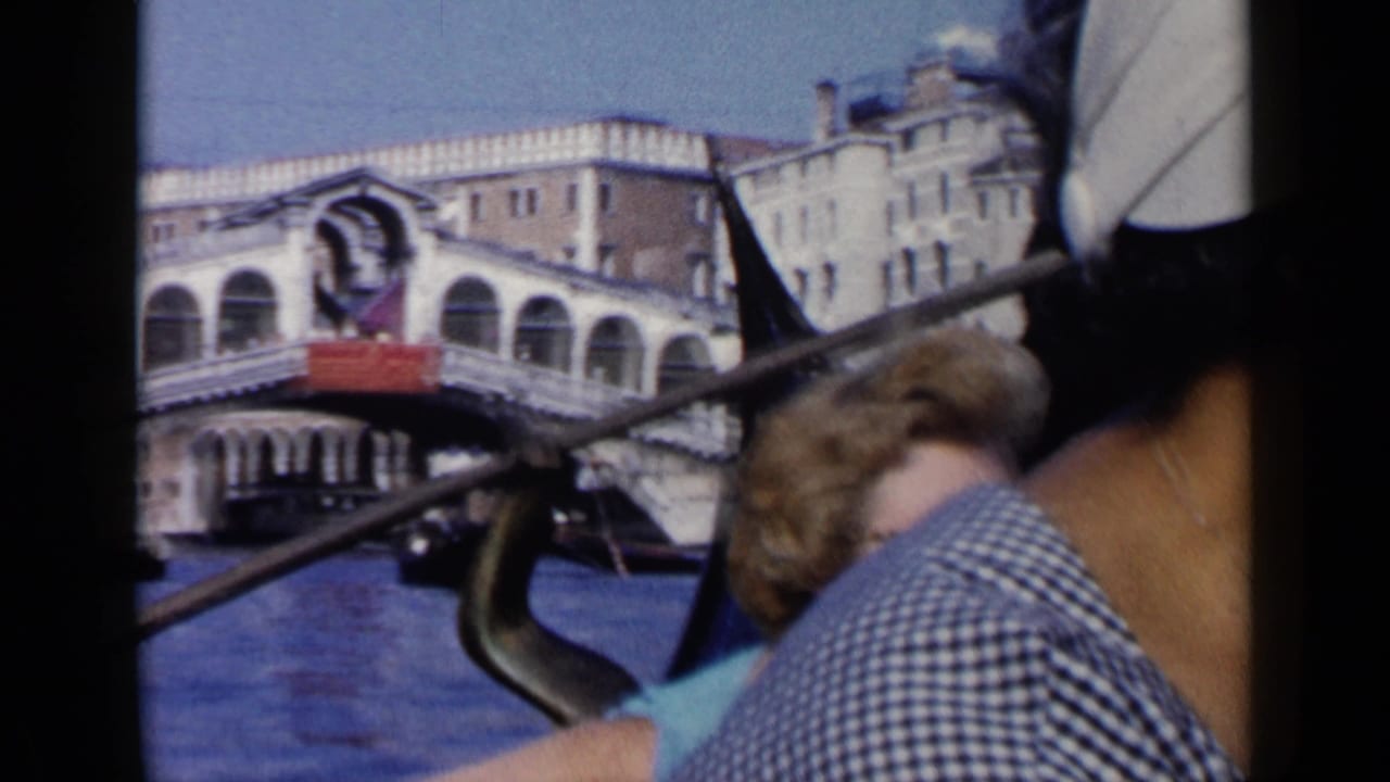 Gondola passengers pass the Rialto Bridge on a Venice canal.