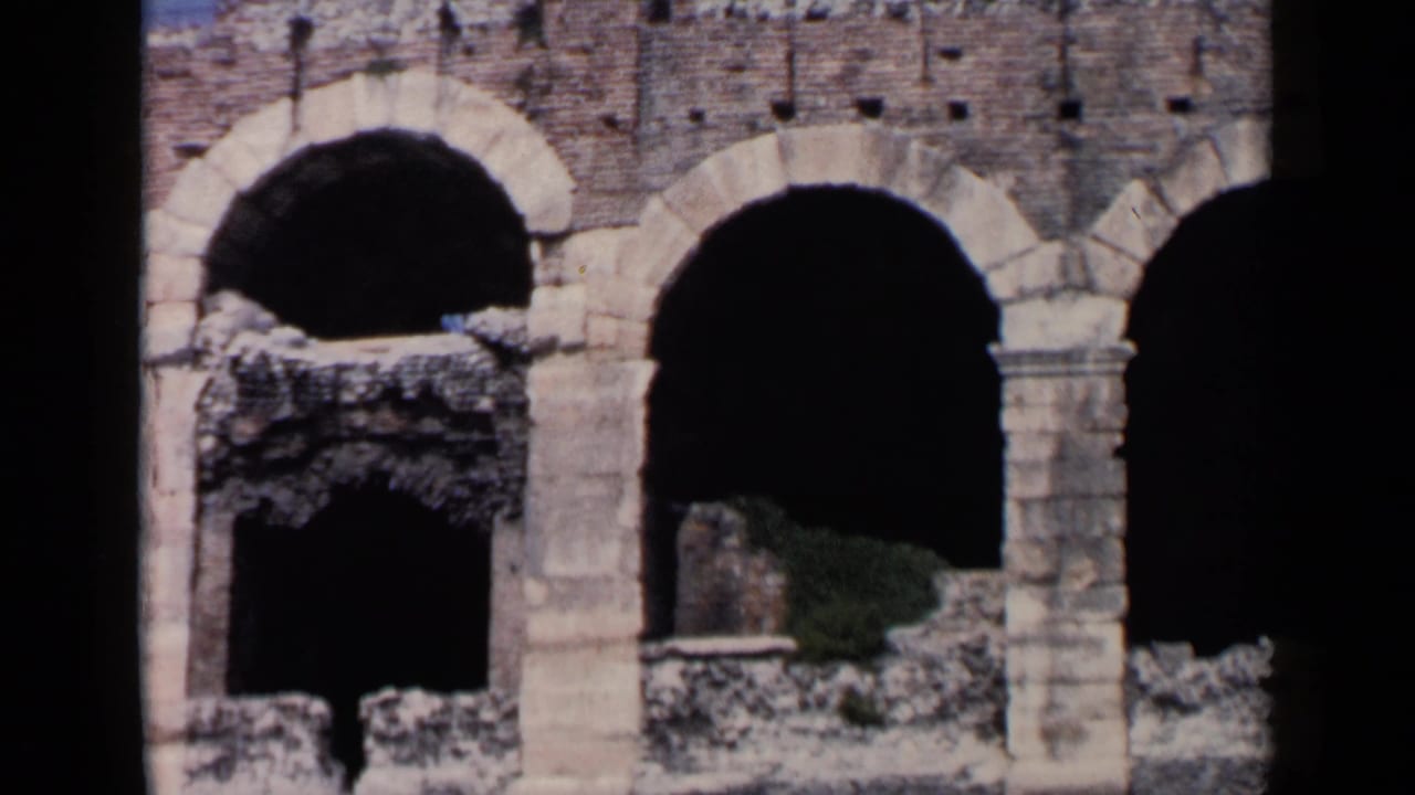 Stone arches and dark openings in an old architectural facade.
