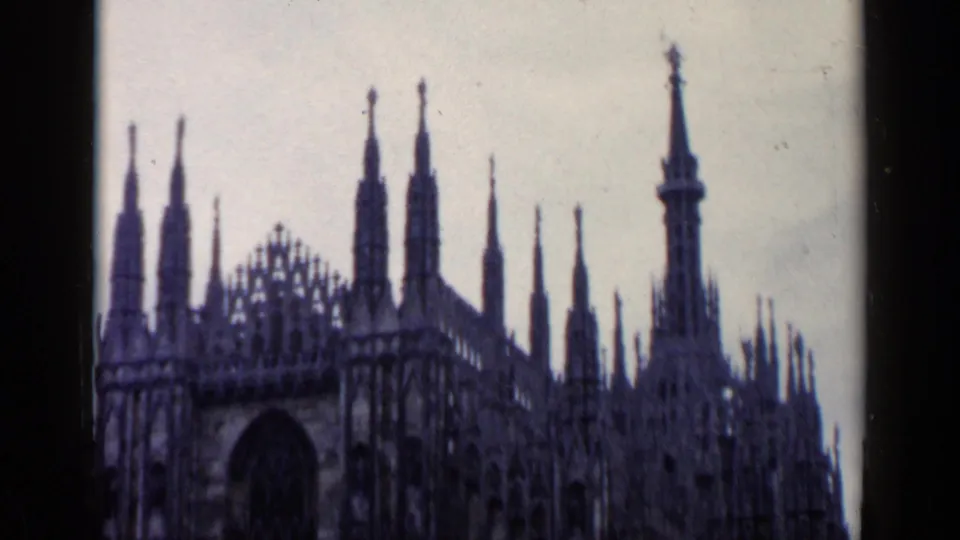 Milan Cathedral's Gothic spires and ornate upper facade appear in soft, faded 1960s 8mm footage.