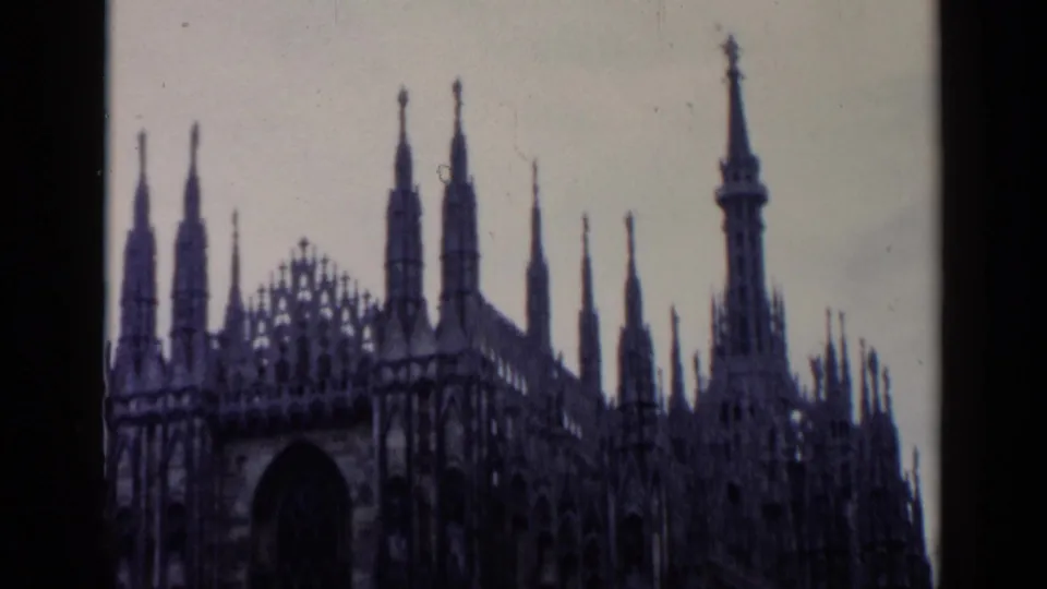 1960s 8mm frame of Milan Cathedral with tall pinnacles, ornate stonework, and a large arched entrance.