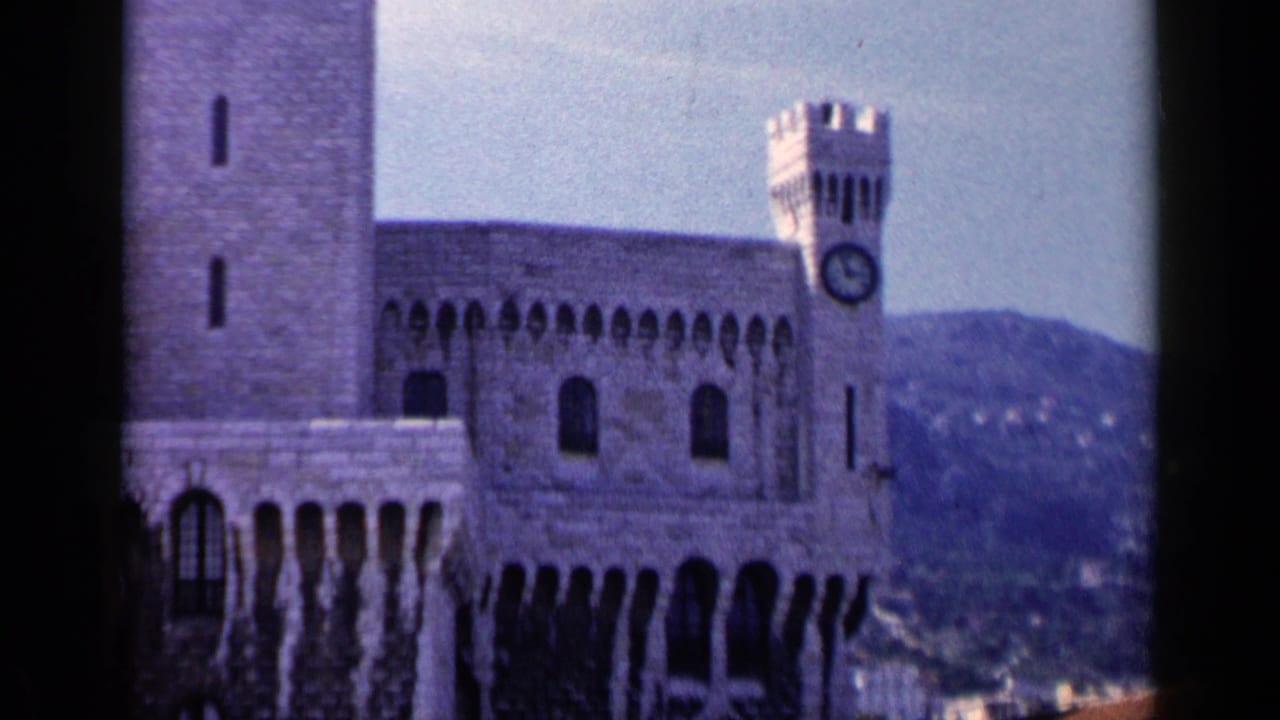 Stone landmark with arched windows, a clock tower, and distant hills behind it.