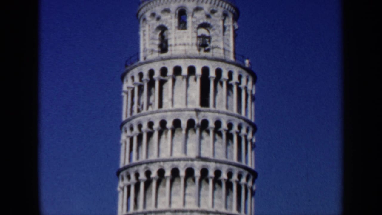 Close view of the Leaning Tower of Pisa against a deep blue sky.