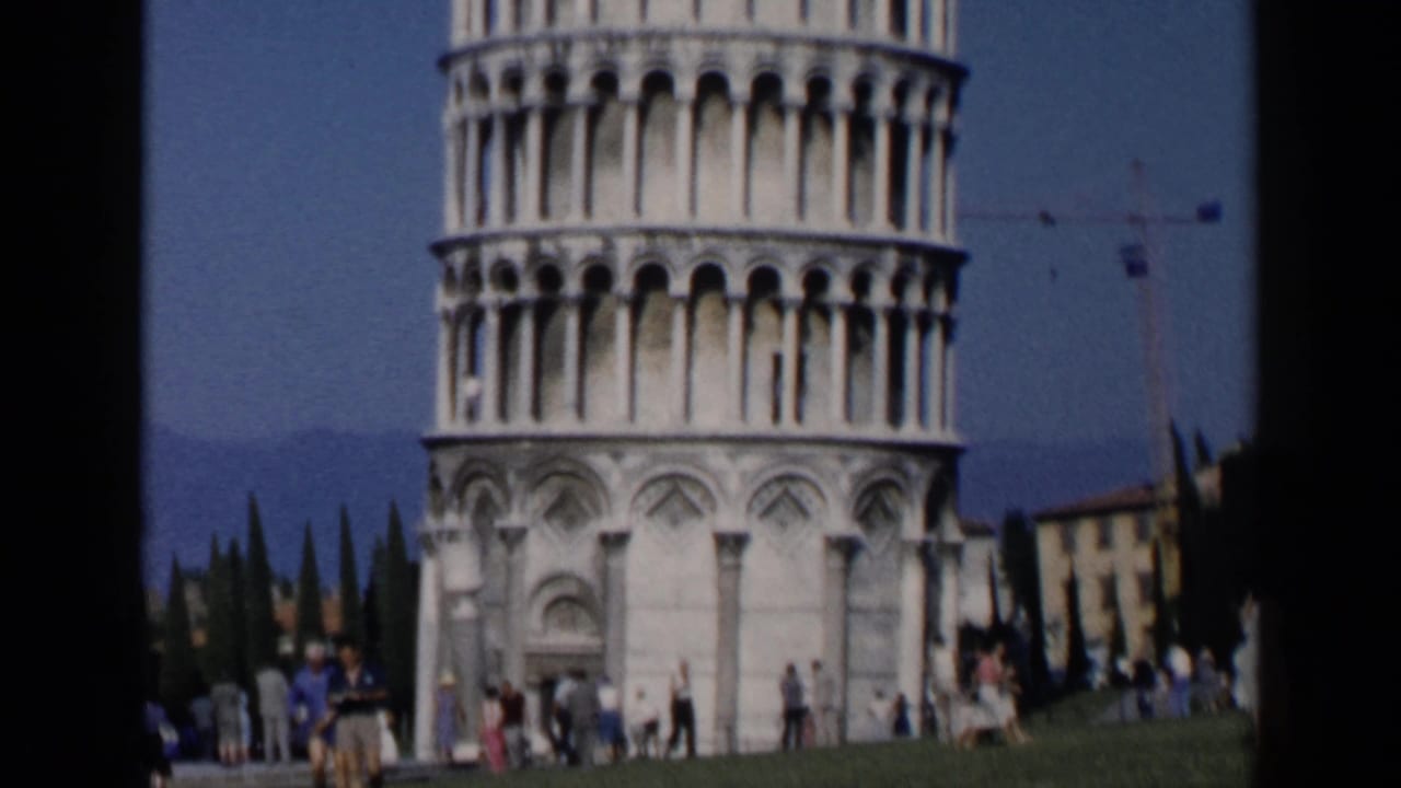 Leaning Tower of Pisa with tourists gathered on the lawn below.