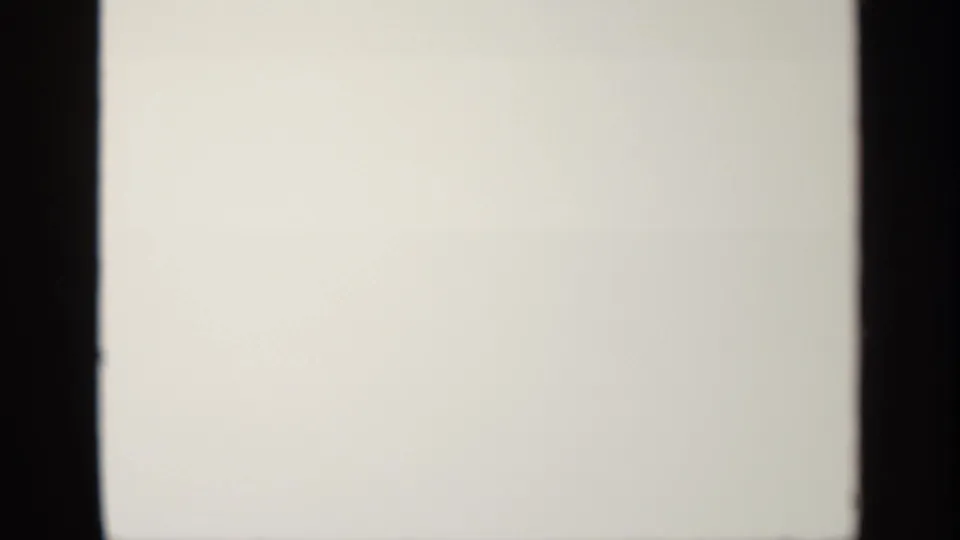 Blank or overexposed 8mm frame following the tower view, with pale field, dark film edges, and visible scan or contact-sheet division.