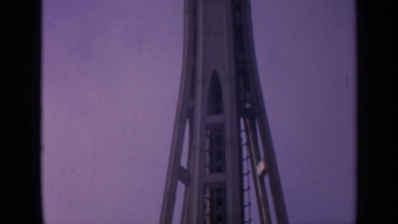 Space Needle upper shaft against a purple evening sky.