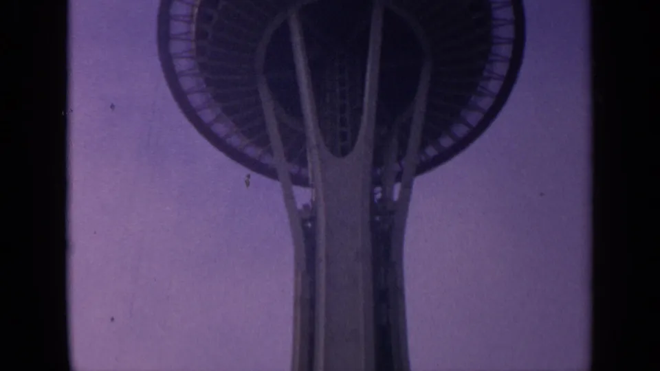 The Space Needle's saucer-like deck is centered in a soft, purple-tinted 8mm frame.