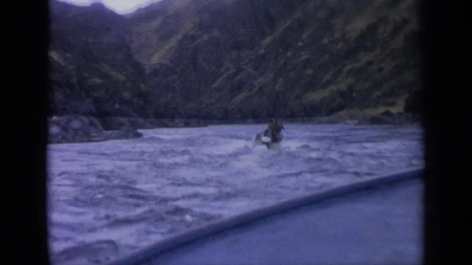 1963 Idaho travel footage showing a motorboat ahead from another vessel on a rough mountain river.