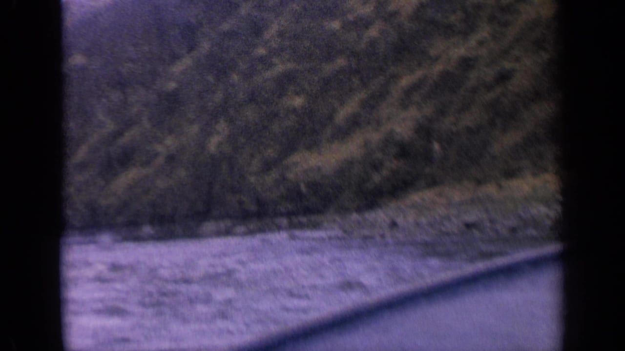 River and forested mountain slope seen through dark 8mm frame borders.
