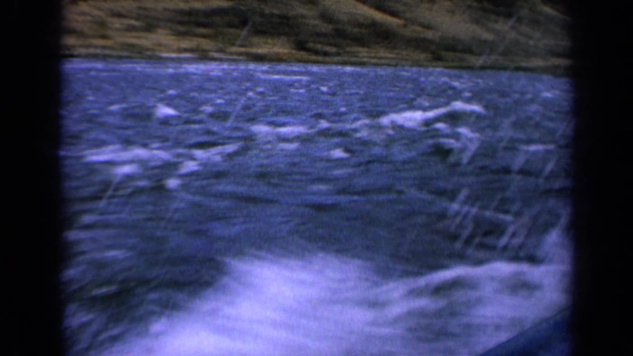 White spray and rough blue river water beside a moving boat.