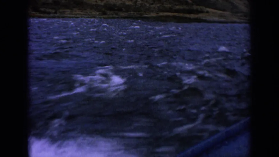 Final 1963 Idaho 8mm frame showing choppy river water, white spray, and a distant grassy bank from a fast-moving boat.