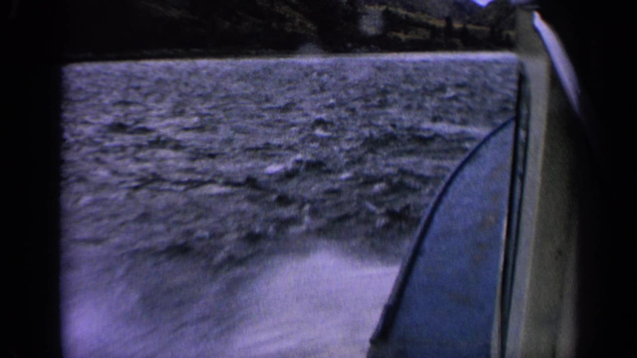 8mm Idaho lake-travel view with the boat side at right and a blurred wake sweeping across the foreground.