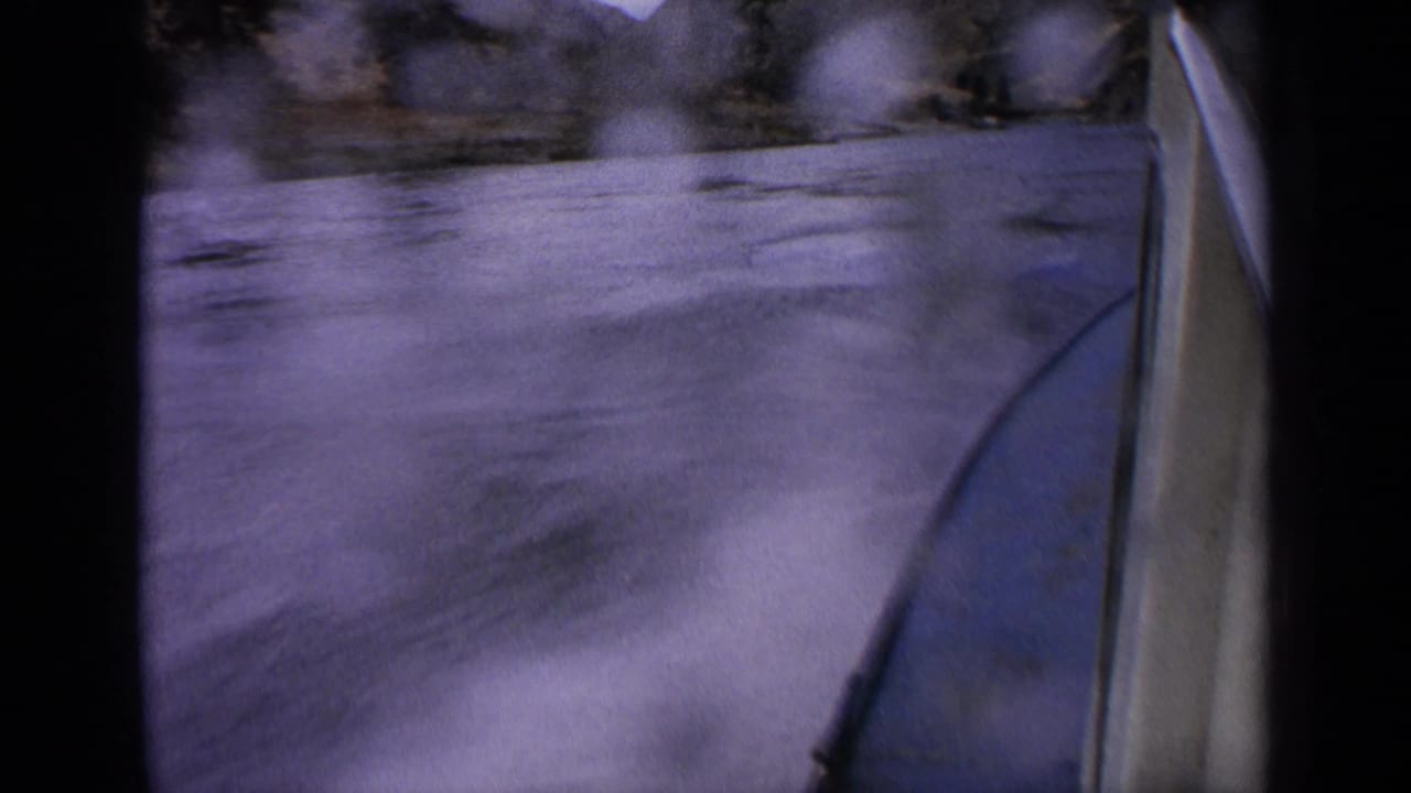 Moving boat edge beside blurred river water and distant rocky canyon.