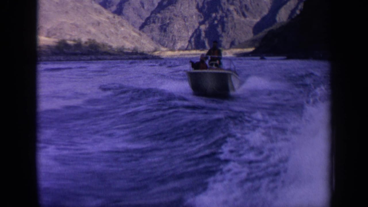 Final 1963 Idaho frame shows the small motorboat farther ahead, with broad wake and rocky canyon terrain around the river.