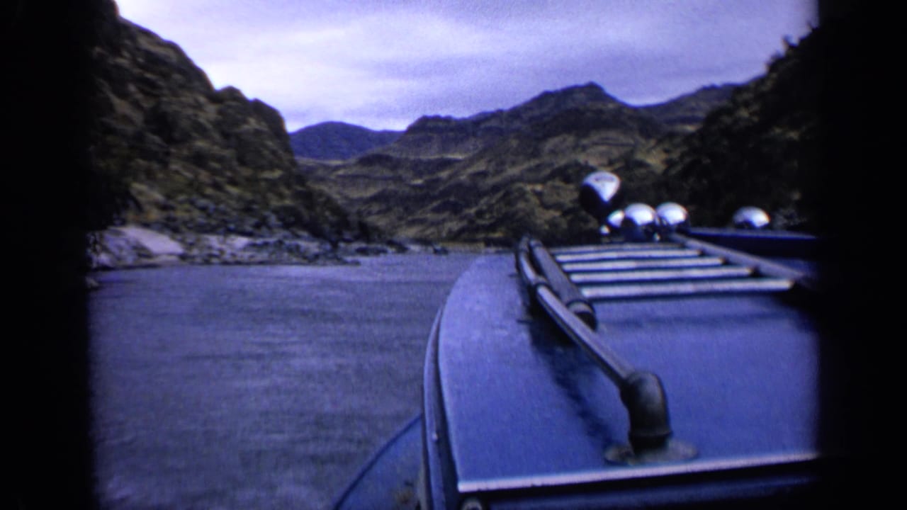 1963 Idaho 8mm boat POV showing rocky shoreline, open water, and layered canyon hills.