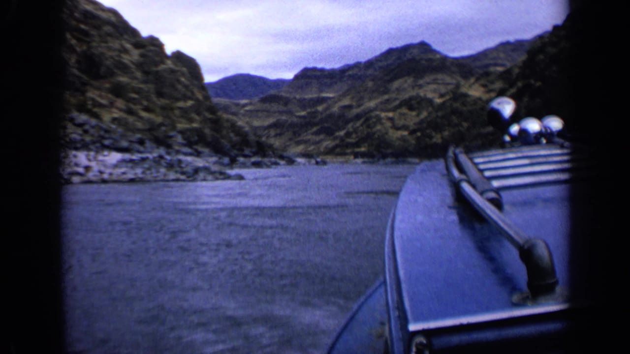1963 Idaho 8mm frame with the boat edge at right as the river runs through a rugged canyon.