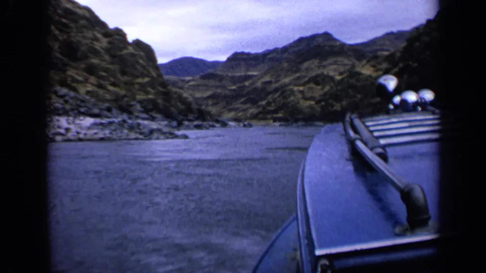1963 Idaho 8mm frame with the boat edge at right as the river runs through a rugged canyon.