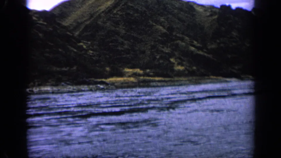 1963 Idaho 8mm still showing the river closer to the foreground, with steep shadowed slopes beyond it.