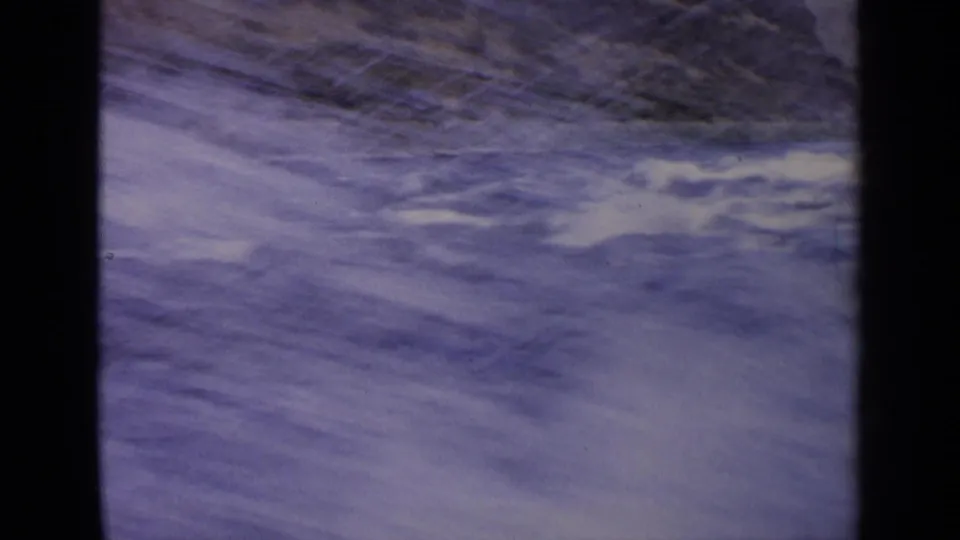 1963 Idaho 8mm frame showing rushing blue water, white foam, and a sloped rocky bank in soft handheld focus.